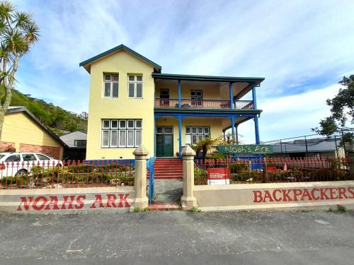 a yellow house with a sign in front of it at Noah's Ark Flashpacker in Greymouth