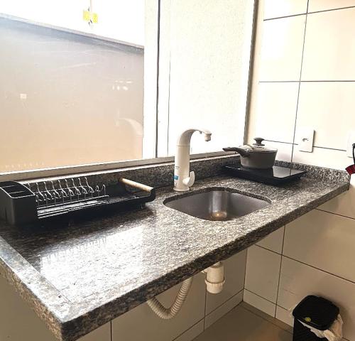 a kitchen counter top with a sink and a window at Casa 03 - Casa com 2 quartos, localizada próximo a rodoviária e aeroporto in Palmas