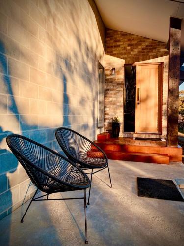 two chairs sitting on a patio with a building at Modern Two Bedroom Waterfront Apartment in Jindabyne