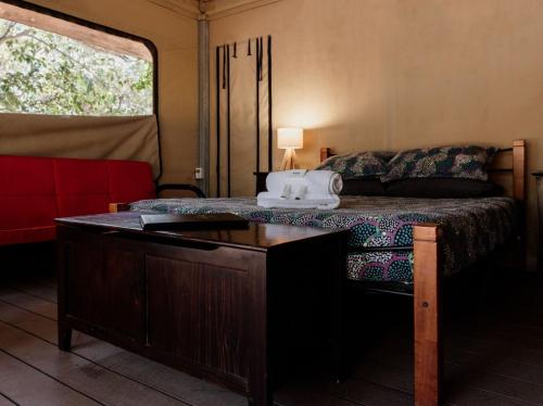 Un dormitorio con una cama y una mesa en una habitación. en Breeze Holiday Parks - Mary River, en Marrakai