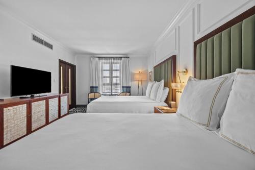 una habitación de hotel con dos camas y un televisor de pantalla plana en Condado Vanderbilt Hotel, en San Juan