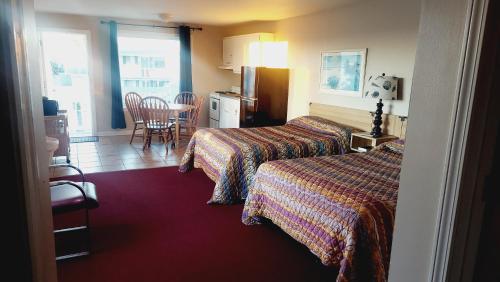 a hotel room with two beds and a table at Dolphin Lane Motel in Carolina Beach