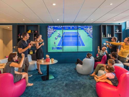 a group of people in a room playing a video game at Novotel Lyon Bron Meeting & Events in Bron