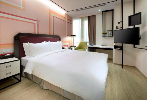 台北的住宿－悠逸商旅台北士林，酒店客房设有一张白色大床和一张书桌