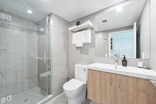 a bathroom with a toilet and a sink and a shower at Albany Oak Motel in Auckland