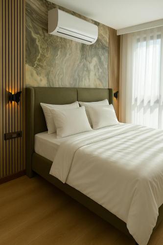 a bedroom with a large bed with white pillows at Positive Hotel in Arnavutköy