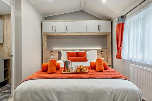 a large bed with a tray of food on it at Astoria Lodge Smart Modern 2-Bedroom Holiday Lodge Milford on Sea in Milford on Sea