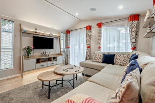 a living room with a couch and a table at Astoria Lodge Smart Modern 2-Bedroom Holiday Lodge Milford on Sea in Milford on Sea