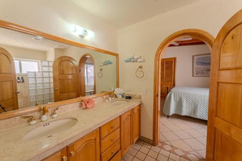 a bathroom with a sink and a mirror and a bed at Las Palmas Resort in Puerto Peñasco