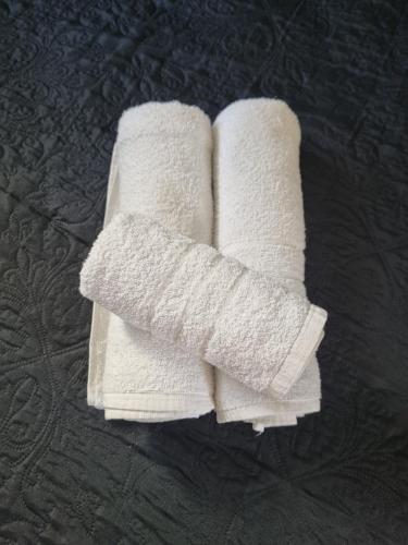 two rolls of white towels sitting on a table at Cantinho de aconchego 02 - com ar condicionado in Barretos