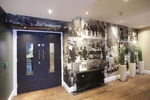 um corredor com uma parede com fotografias em The Angel Hotel Wetherspoon em Whitby