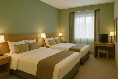 a hotel room with two beds and a window at The Grand Sanken Hotel in Kalodran