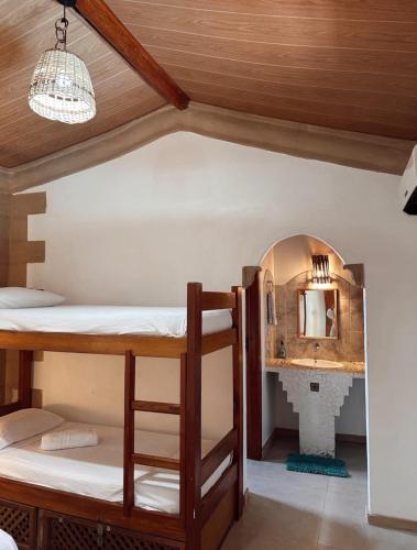 a room with two bunk beds and a mirror at Na Casa 11 - Pousada in Arraial d'Ajuda
