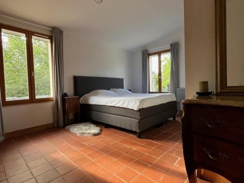 une chambre avec un lit et deux fenêtres dans l'établissement Gite Foussimagne, à Sérignac