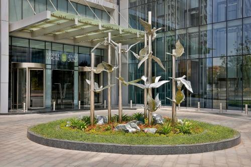 迪拜Hotel Local Dubai, Jumeirah Village Triangle, Autograph Collection的建筑物前的鸟类雕塑