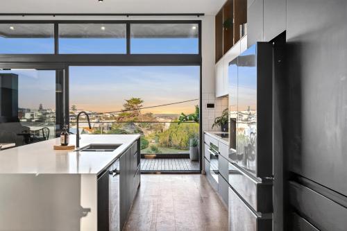 een keuken met een groot raam met uitzicht bij Ocean-View Luxury, Spa, Fire Pit & Ocean Views in Ocean Grove