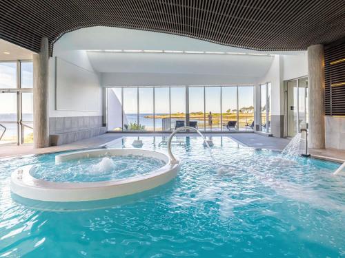 Una gran piscina con jacuzzi en un edificio. en Sofitel Quiberon Thalassa sea & spa, en Quiberon