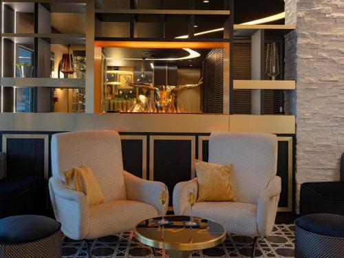 a lobby with two chairs and a coffee table at Mercure Orléans Centre Bords de Loire in Orléans