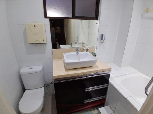 a white bathroom with a sink and a toilet at Nadi Airport Transit Hotel in Nadi