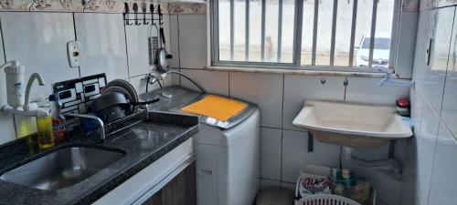 a small kitchen with a sink and a washing machine at Conforto e Lazer no Coração da Ilha de São Luís in São-José-do-Ribamar