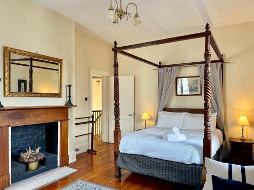 a bedroom with a four poster bed and a fireplace at Grand Old Duke in Hobart
