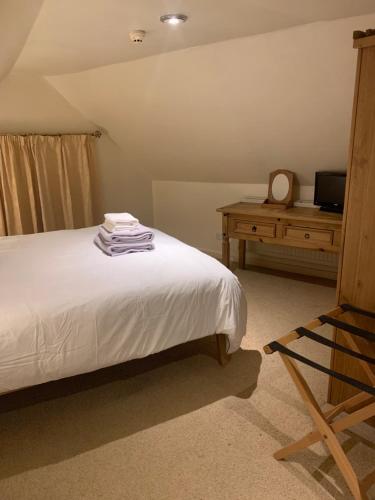 1 dormitorio con cama y mesa con espejo en The Lord Nelson Inn, en Marshfield