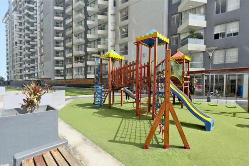 a playground with a slide on a green field at Departamento con Vista al Mar in Lima