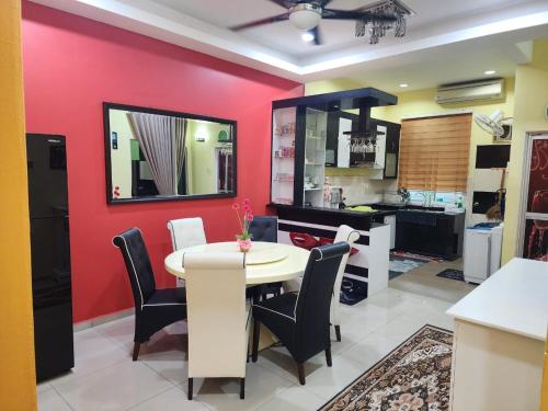 a dining room with a table and a red wall at HOMESTAY RIZQI - MUS LIM Only in Air Molek