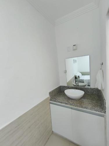 a bathroom with a sink and a mirror at Essenza Suites Natal in Natal