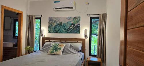 博卡斯德尔托罗Bamboo Lodge的带一张床和两扇窗户的卧室