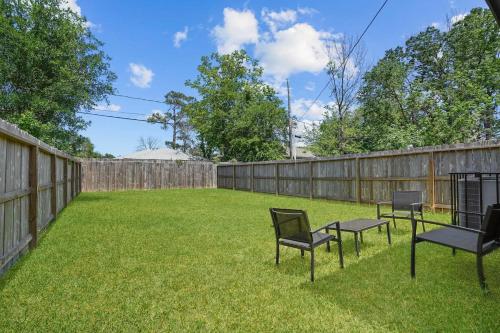 a yard with three chairs and a fence at Modern and Cozy Home in HTX in Houston