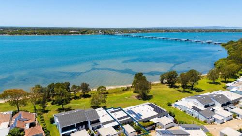an aerial view of a beach with houses and a dock at The Luxe Waterfront in Sandstone Point