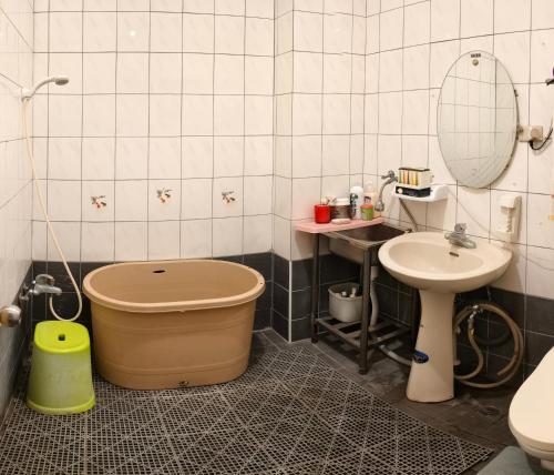 a bathroom with a tub next to a sink and a toilet at 山頂洞人 in Fengyuan