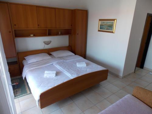 a bedroom with a bed with two white pillows at Double Room Barbat 4862a in Barbat na Rabu