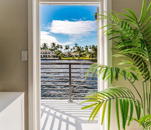 eine Tür zu einem Balkon mit Blick auf das Wasser in der Unterkunft Waterfront Intercoastal, Walk to the Beach, Pool & Hot Tub, Watch the Boats in Boca Raton