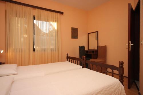 a bedroom with two beds and a mirror and a window at Apartment Pomer 7374a in Pomer