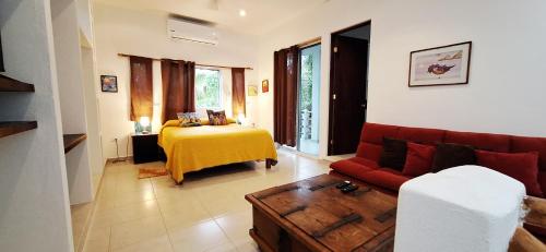a living room with a red couch and a table at MINI PINI BIRD WATCHING AND CENOTE Loft in Cozumel