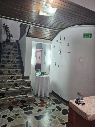 a room with a clock on the wall and a table at Hotel Americano Plus in Pereira