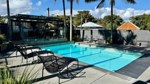 Una piscina con sillas al lado de una casa. en The Pool House -New Listing Promo, en Russell