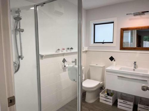 Un baño blanco con inodoro y lavabo. en The Pool House -New Listing Promo, en Russell