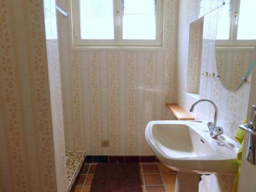a bathroom with a sink and a window and a shower at Holiday Home in Plozévet near Beaches in Plozévet