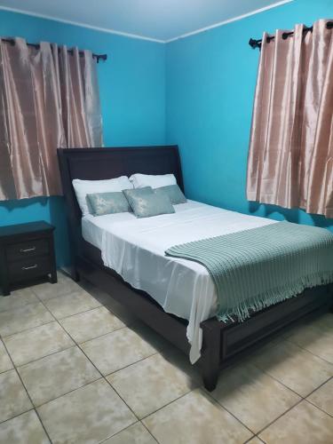 a bed in a room with a blue wall at Ashmak apartment in Mahaut