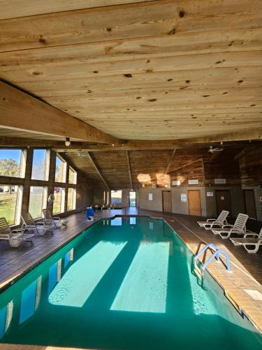 a swimming pool in a building with a wooden ceiling at Ramada by Wyndham Platte City KCI Airport in Platte City