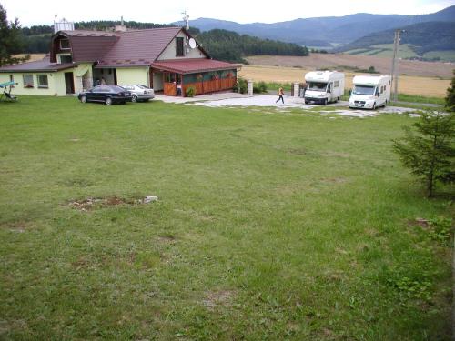 a yard with two trucks parked in front of a house at Penzion Dreveník in Spišské Podhradie