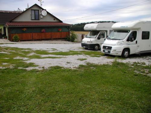 two trucks parked in a parking lot in front of a house at Penzion Dreveník in Spišské Podhradie