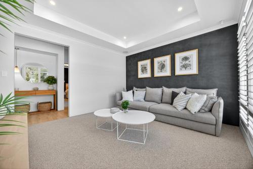 a living room with a couch and a table at Coastal Luxe 4-Bed House in Madora Bay in Singleton