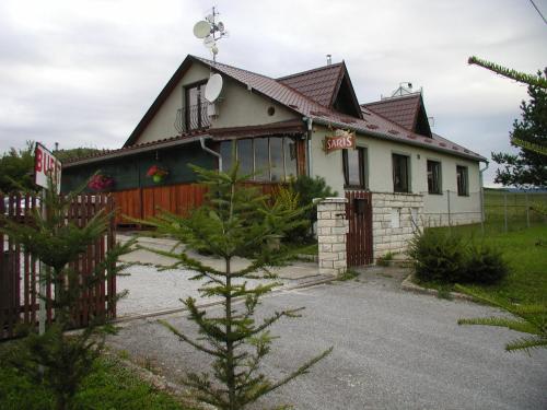 a house with a fence in front of it at Penzion Dreveník in Spišské Podhradie
