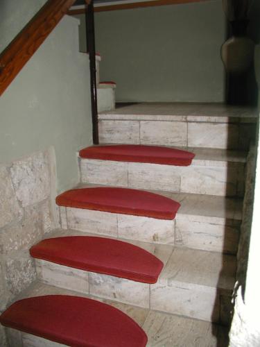 a set of stairs with red mats on them at Penzion Dreveník in Spišské Podhradie
