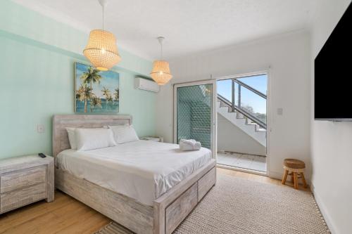 a bedroom with a large bed and a balcony at Spacious 2-Bed with Private Rooftop & BBQ Access in Brisbane