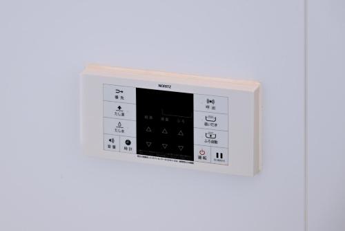 a white microwave oven on a white wall at お宿 岸ノ四季 in Kishiwada